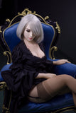 Elegant 170cm Akiko sex doll wearing a black lace robe and sheer stockings, showcasing her K-Cup breasts while seated on a royal blue armchair, with stylish short platinum blonde hair.