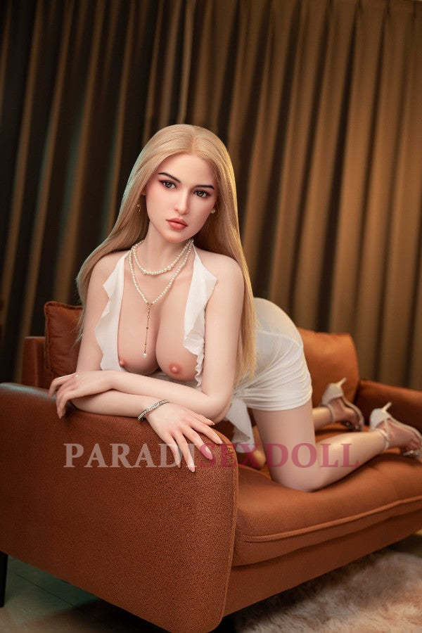 Life size silicone sex doll Kiana 5FT with natural color, white lingerie and realistic features, displayed on brown chaise lounge.