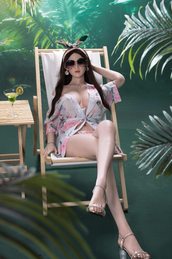 Silicone full-size realistic sex doll in white lingerie posing in tropical rainforest style setting
