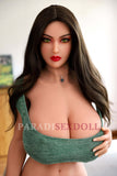 Adelaide, a realistic sex doll with long dark hair and striking green eyes, wearing a tight green crop top that showcases her voluptuous figure. The doll is positioned in a well-decorated living room, emphasizing her beauty and lifelike attributes.