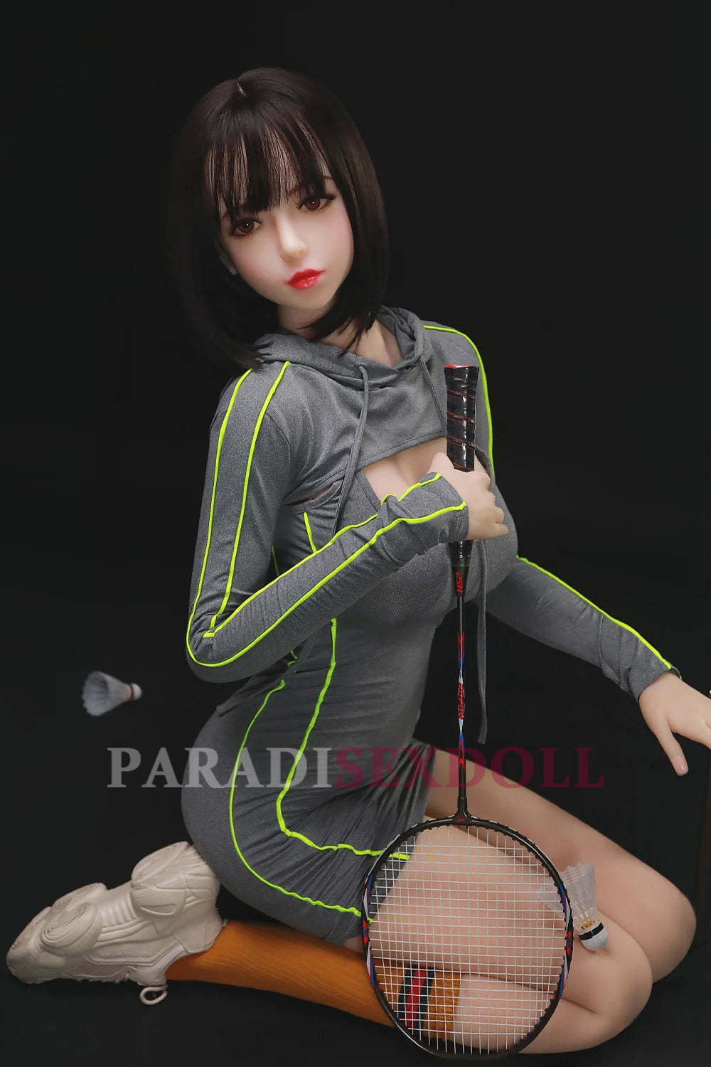 168cm exotic sex doll Olivia in a fitted grey athletic dress with neon stripes, kneeling on a court, holding a badminton racket and showcasing her alluring curves and sporty style, with a shuttlecock nearby.