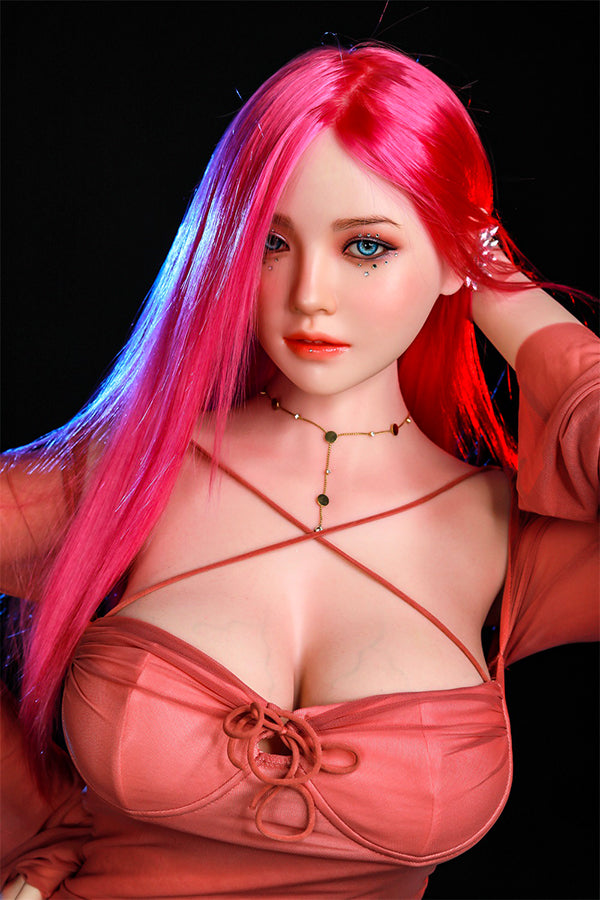 Hyper-realistic Rana silicone sex doll with striking long pink hair and captivating blue eyes, wearing a fitted pink top that accentuates her features, showcasing lifelike skin texture and an inviting expression.