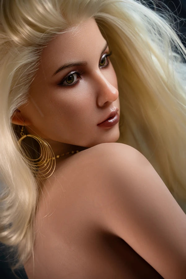 Blonde BBW silicone head sex doll Marigold with flowing blonde hair and a realistic facial expression, wearing gold hoop earrings, posed elegantly with a seductive look against a soft dark backdrop.